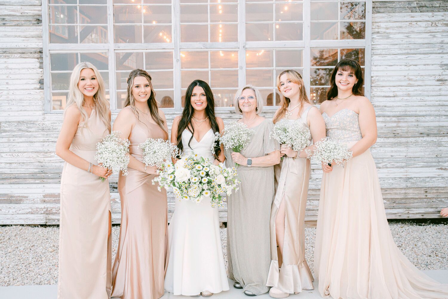 Bride and bridesmaids in front of the chapel windows