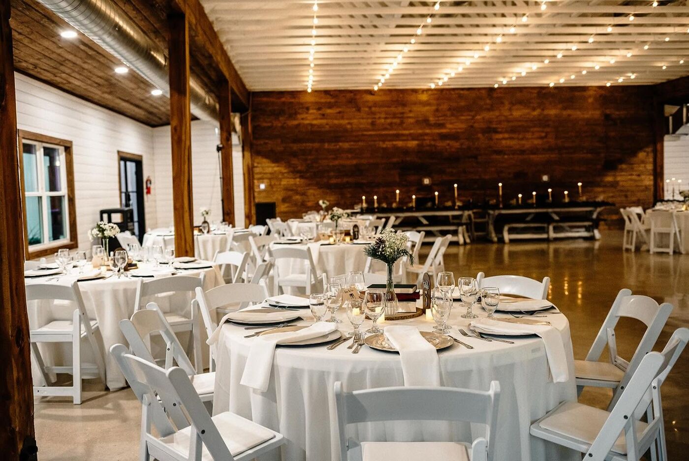 Round tables set with white linens inside the reception hall