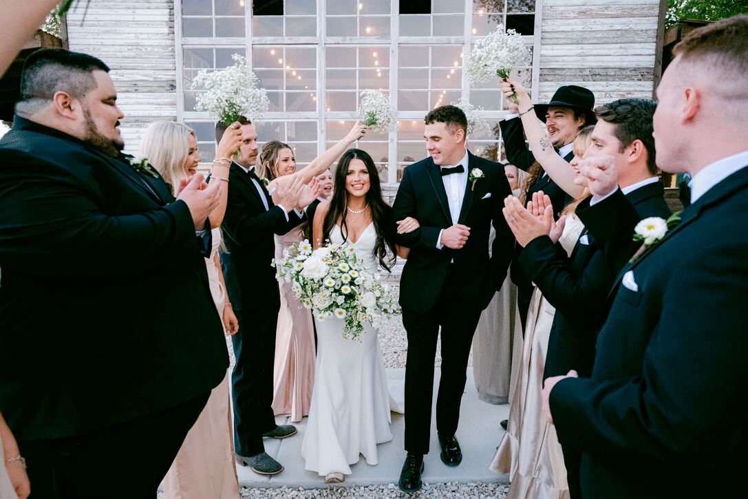 Wedding party cheering as the couple walks through