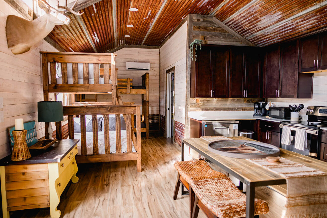 Cabin interior with wooden bunk beds and a full kitchen