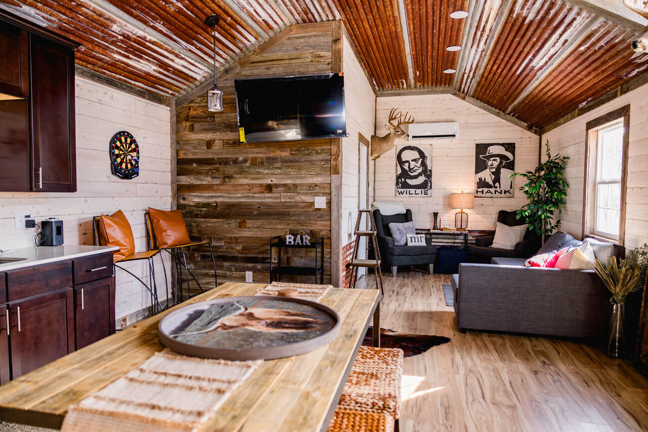 Cabin living area with a sofa, bar seating and a rust-tin ceiling