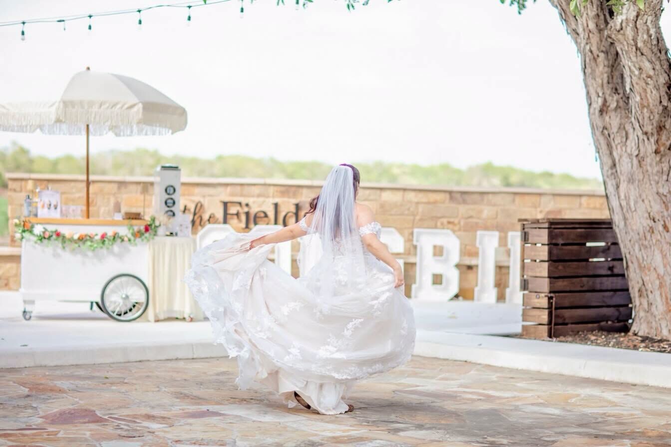 Bride twirling in the courtyard beside a drink cart