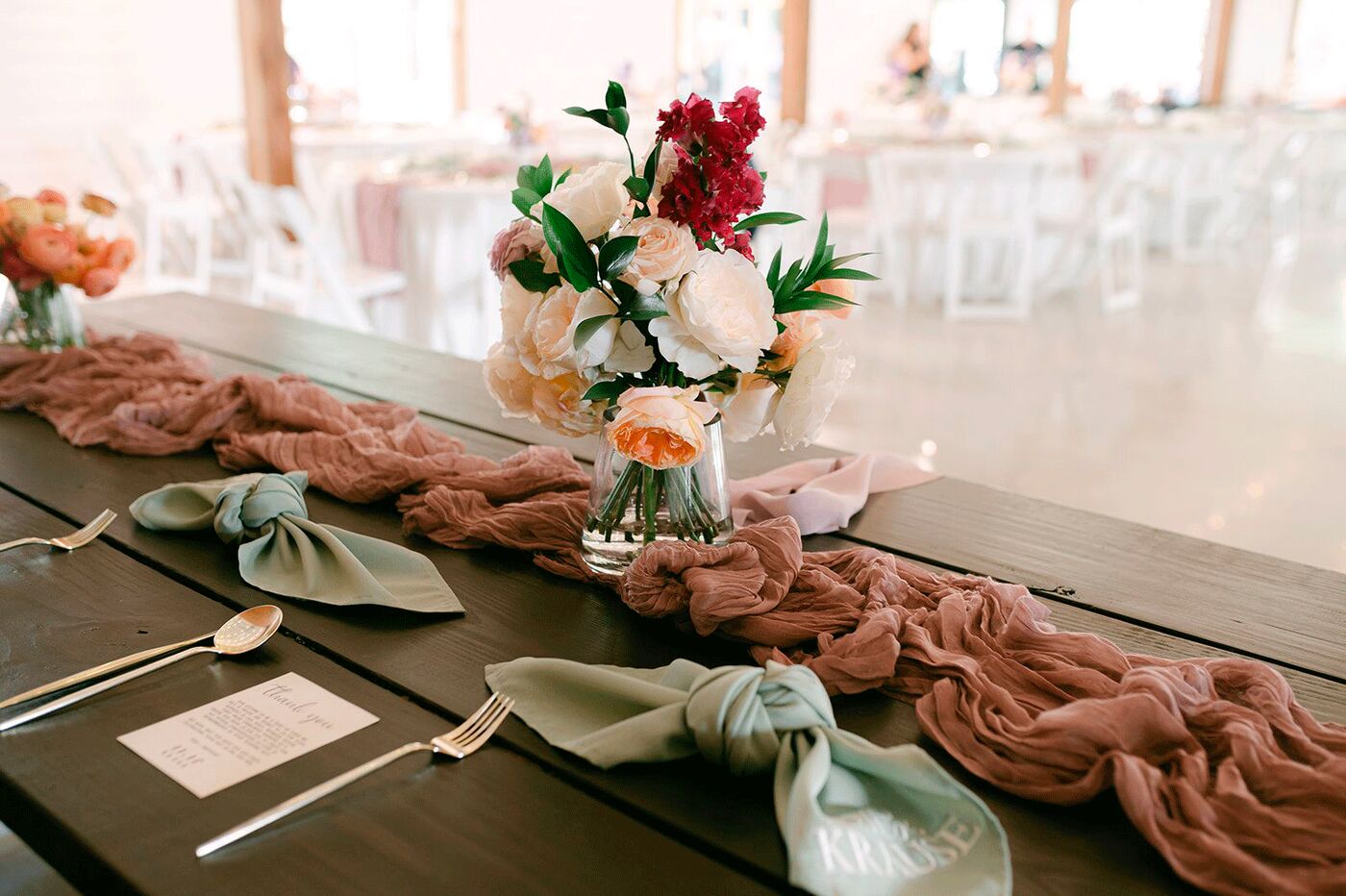 Reception table with flowers, sage napkins and a blush runner