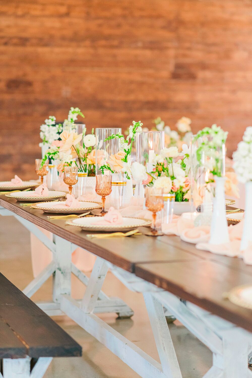 Long farm table set with glassware and flowers
